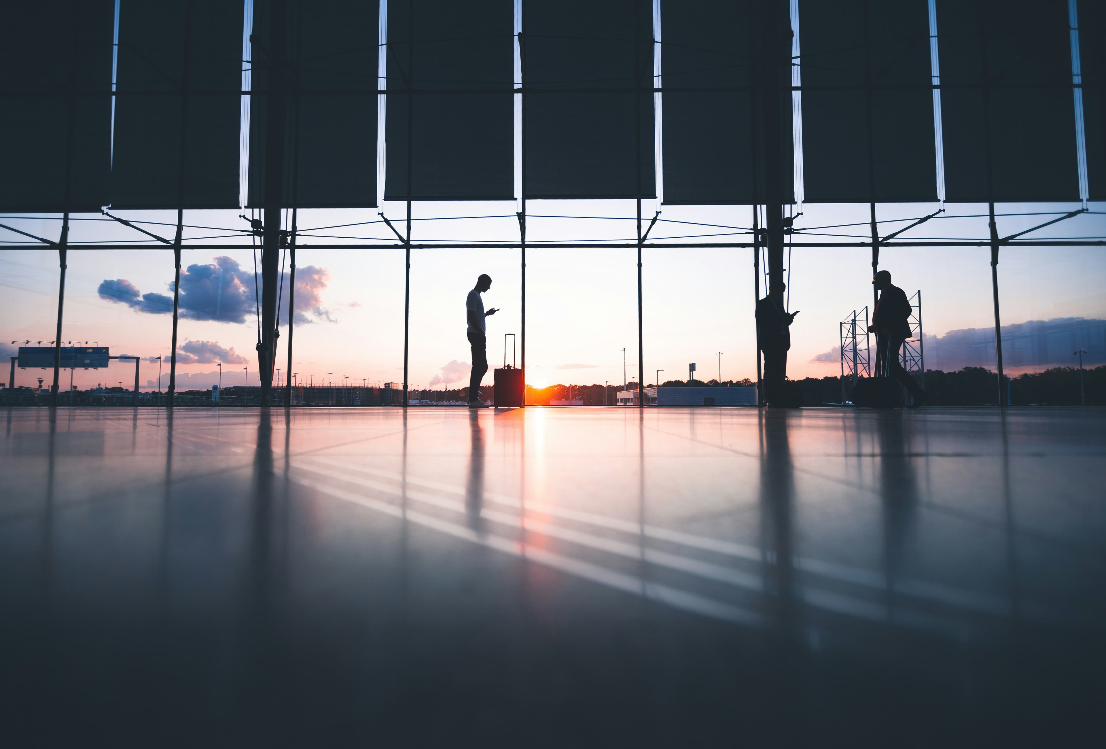Travellers at an airport terminal at sunset